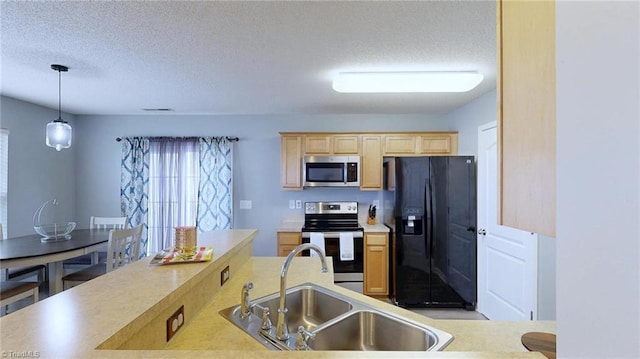 kitchen with pendant lighting, sink, appliances with stainless steel finishes, a textured ceiling, and light brown cabinets