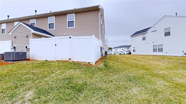 rear view of house featuring a yard and central air condition unit