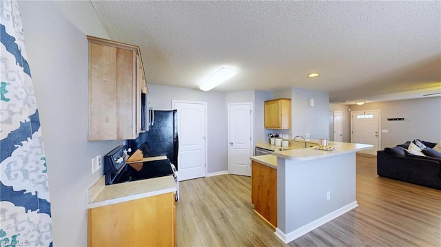 kitchen with stove, a textured ceiling, light brown cabinetry, kitchen peninsula, and light wood-type flooring