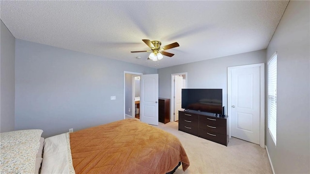 bedroom with light carpet, ceiling fan, and a textured ceiling