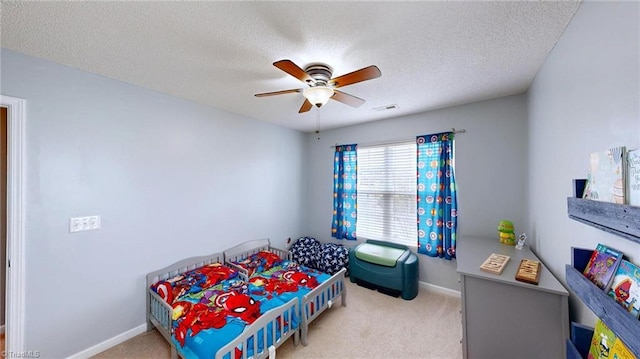 carpeted bedroom with ceiling fan and a textured ceiling