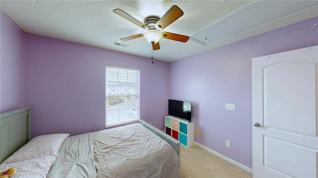 carpeted bedroom featuring ceiling fan and a textured ceiling