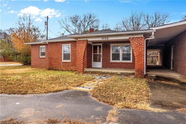 view of front of home featuring a front lawn and a carport