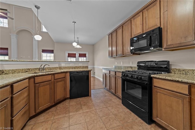 kitchen featuring brown cabinetry, a sink, plenty of natural light, and black appliances