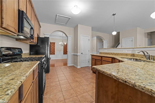 kitchen featuring a sink, arched walkways, black appliances, and light tile patterned flooring