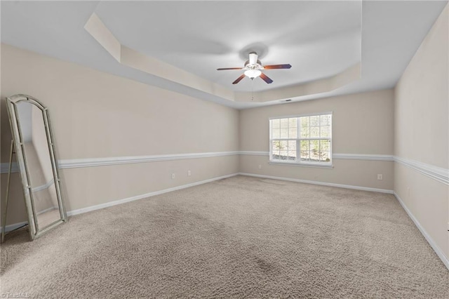 unfurnished room featuring baseboards, a ceiling fan, carpet flooring, and a raised ceiling