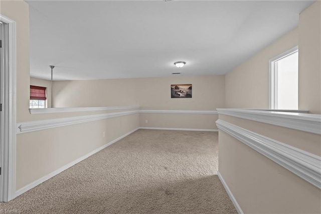 corridor with baseboards and carpet flooring