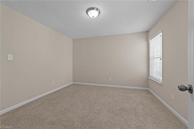 unfurnished room with baseboards and carpet floors