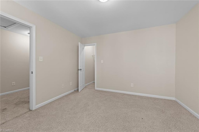 unfurnished room with light colored carpet and baseboards