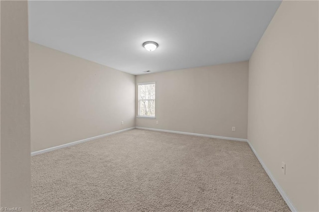 spare room with baseboards and carpet