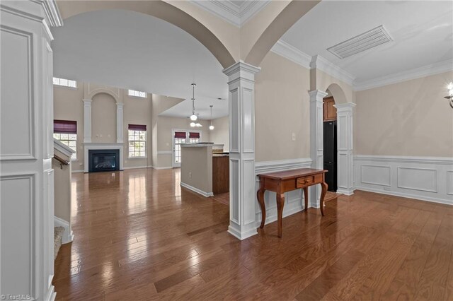 kitchen featuring pendant lighting, open floor plan, visible vents, dark wood-type flooring, and ornate columns