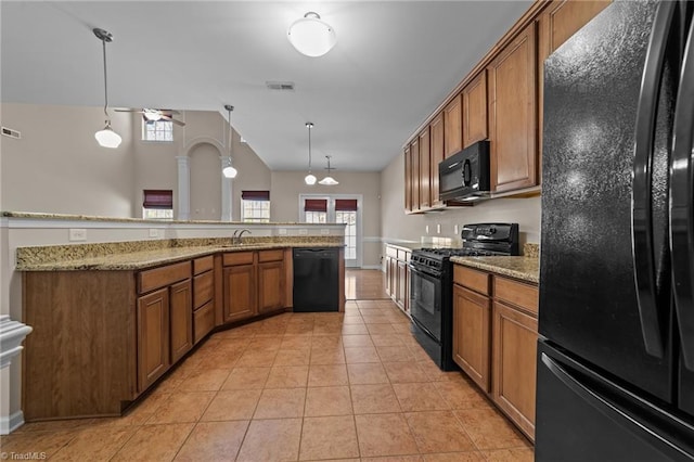 kitchen featuring a sink, light stone countertops, brown cabinets, light tile patterned floors, and black appliances