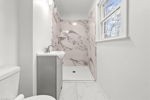 bathroom with vanity, a tile shower, and toilet