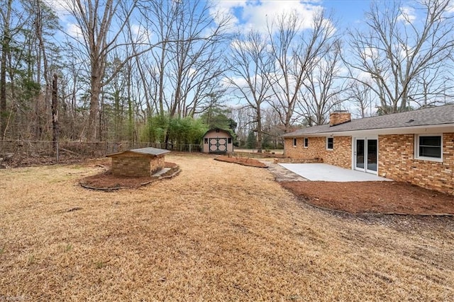 view of yard featuring a storage shed and a patio area