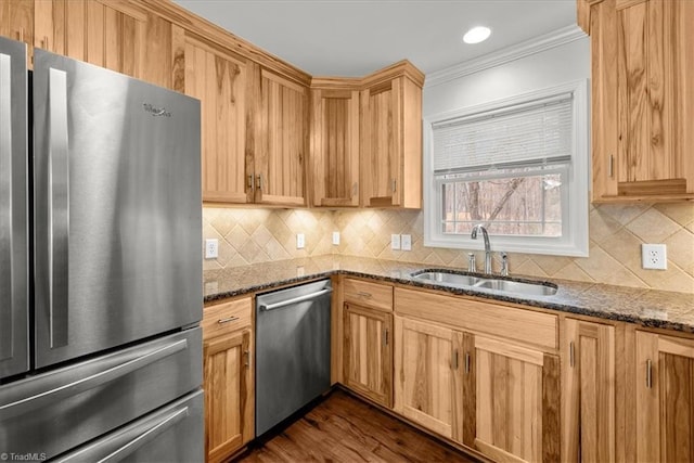 kitchen featuring crown molding, appliances with stainless steel finishes, sink, and dark stone counters