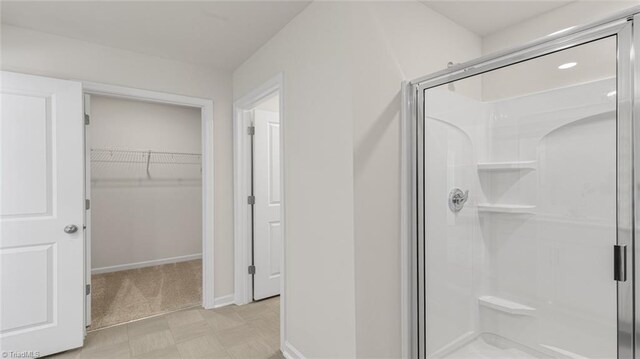 123 Lisa Ln, Winston-Salem, NC 27107 - full bath featuring a spacious closet, a stall shower, tile patterned floors, and baseboards