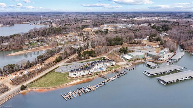 birds eye view of property featuring a forest view and a water view