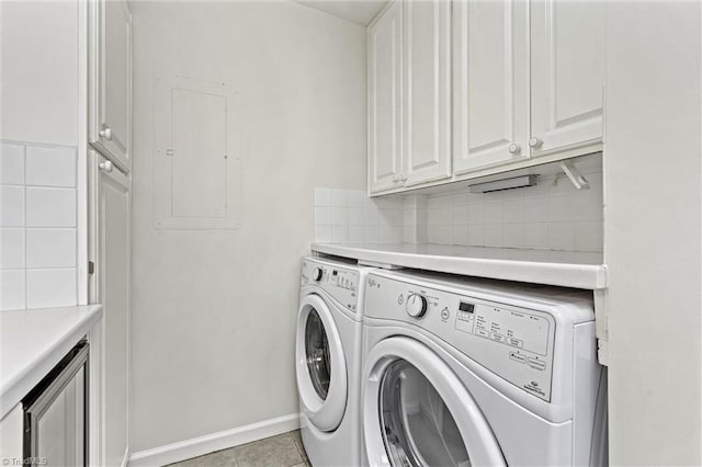 laundry room featuring independent washer and dryer, electric panel, cabinet space, light tile patterned flooring, and baseboards