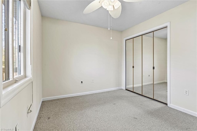unfurnished bedroom with a closet, baseboards, carpet floors, and ceiling fan