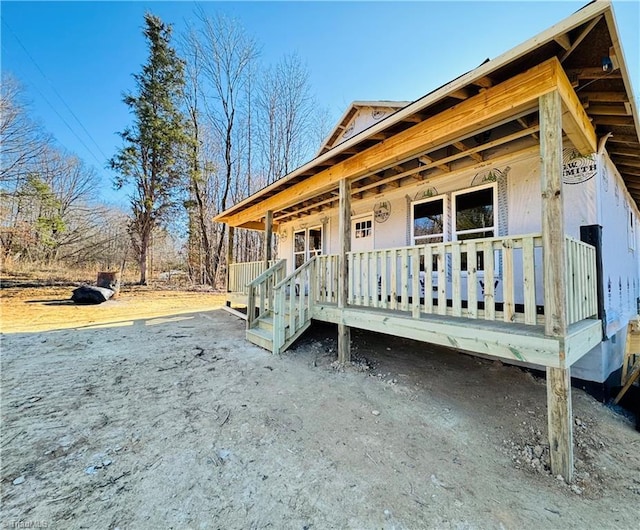 view of side of home featuring covered porch