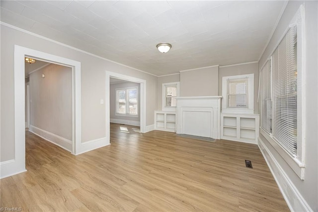 unfurnished living room with crown molding and light hardwood / wood-style floors