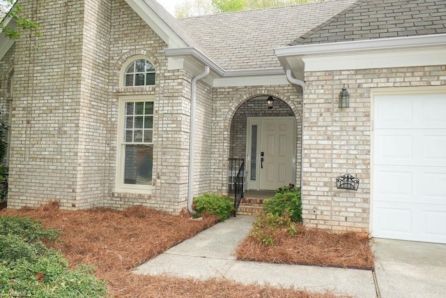 143 Wellesborough Rd, Winston-Salem, NC 27104 - view of exterior entry featuring roof with shingles, a garage, and brick siding