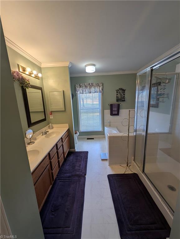 bathroom featuring vanity, crown molding, and independent shower and bath