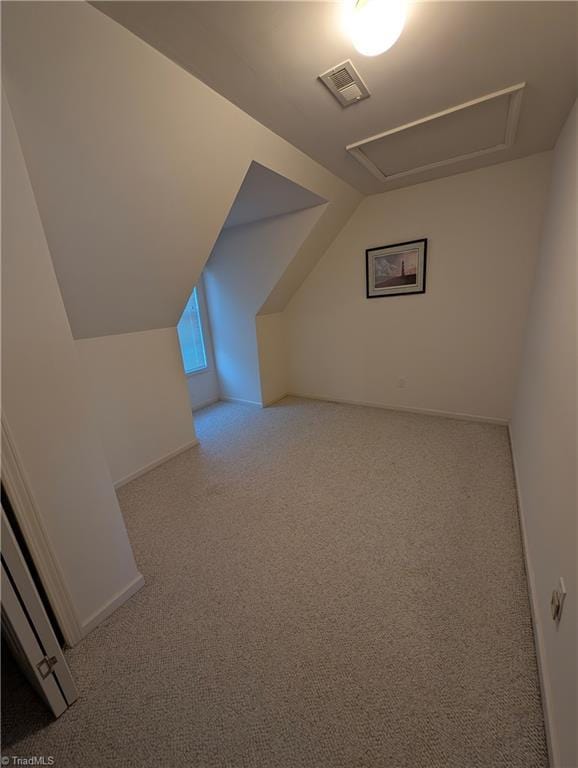 additional living space with vaulted ceiling and light carpet