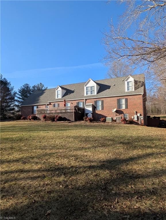 back of property featuring a deck and a yard