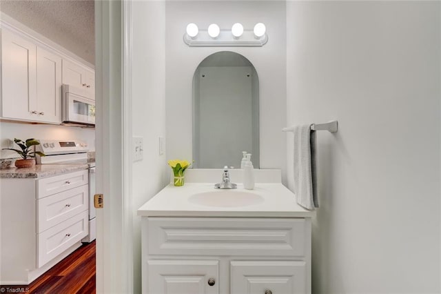 bathroom with wood-type flooring, a textured ceiling, and vanity