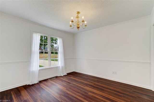 spare room featuring dark wood-type flooring, a textured ceiling, a notable chandelier, and crown molding