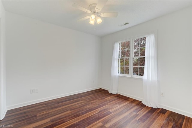 empty room with dark hardwood / wood-style flooring and ceiling fan