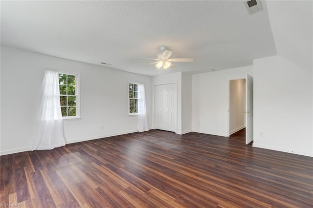 empty room with ceiling fan, a textured ceiling, and dark hardwood / wood-style floors