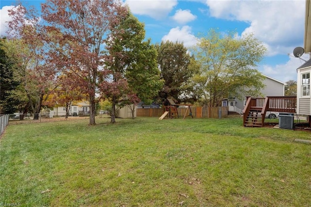 view of yard with a playground, a storage shed, a wooden deck, and central AC