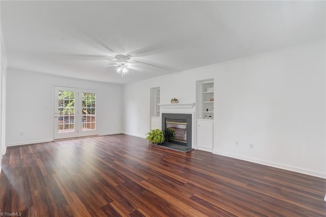 unfurnished living room with dark hardwood / wood-style flooring, ceiling fan, and built in shelves