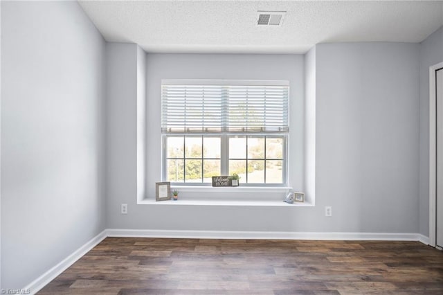 unfurnished room featuring a textured ceiling and dark hardwood / wood-style flooring