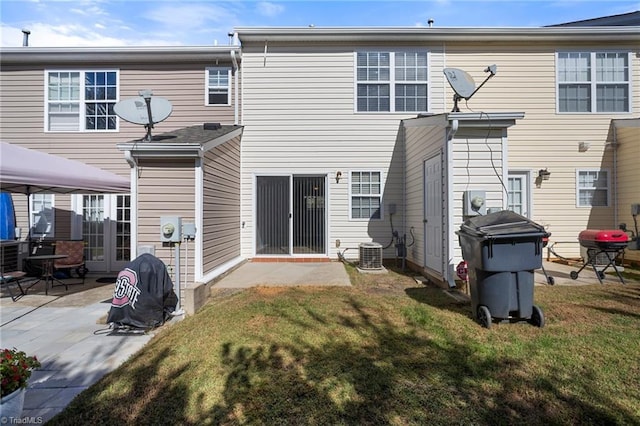 back of house with a patio area and a lawn