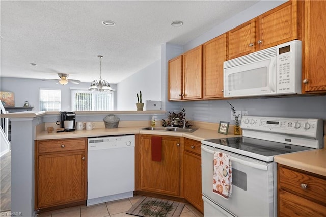 kitchen with sink, kitchen peninsula, a textured ceiling, white appliances, and pendant lighting