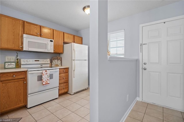 kitchen with light tile patterned flooring and white appliances