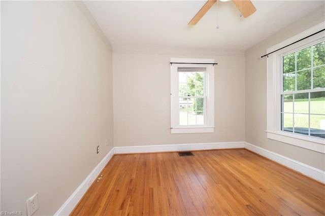 spare room featuring plenty of natural light, light hardwood / wood-style floors, and ceiling fan