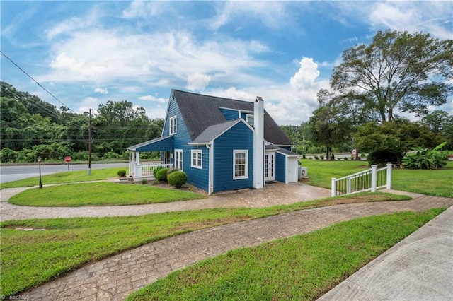 view of side of property with a garage, a yard, and covered porch