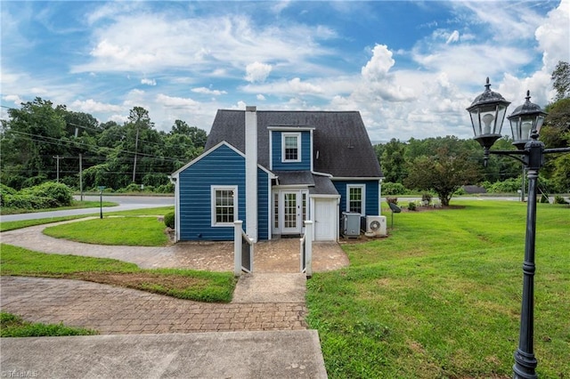 view of front of property featuring ac unit and a front yard