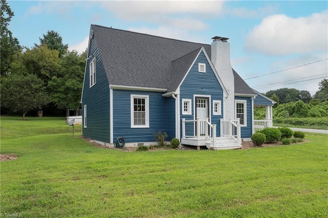 rear view of house featuring a yard