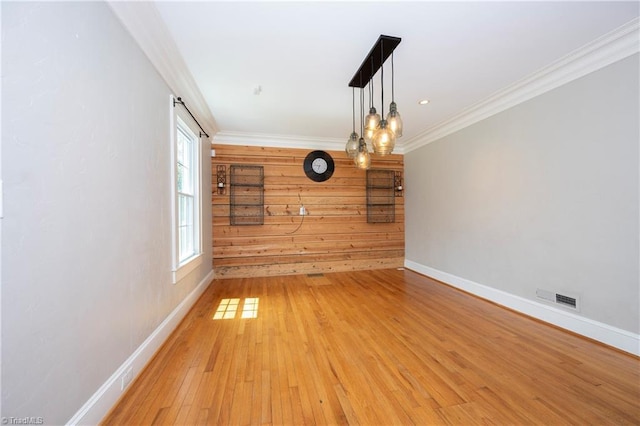 unfurnished dining area featuring a healthy amount of sunlight, ornamental molding, and hardwood / wood-style floors