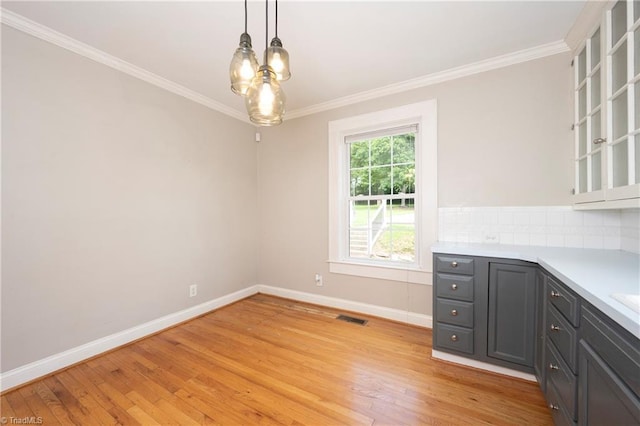 unfurnished dining area with crown molding and light hardwood / wood-style floors