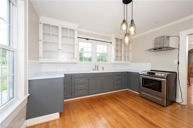 kitchen with wall chimney range hood, sink, gray cabinetry, hanging light fixtures, and stainless steel electric range oven