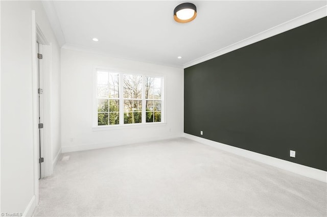 carpeted spare room featuring crown molding