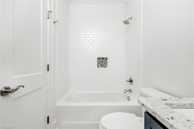 full bathroom featuring tiled shower / bath, vanity, and toilet