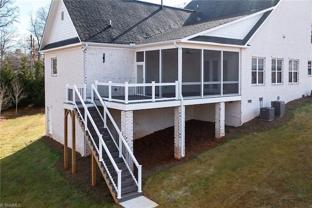 back of property with a yard, a sunroom, and central air condition unit