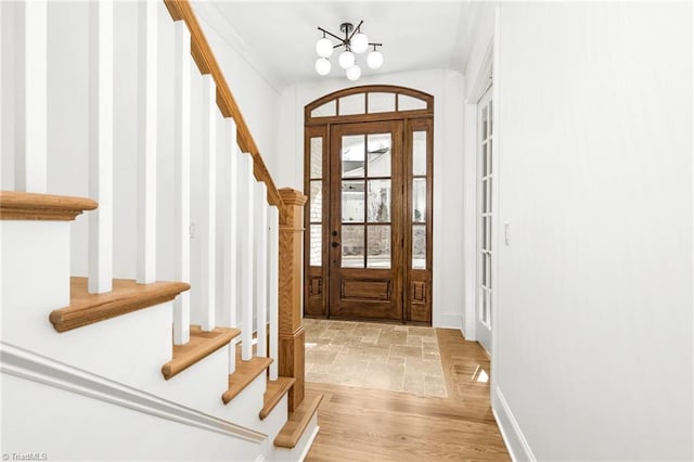 doorway with a notable chandelier and light wood-type flooring